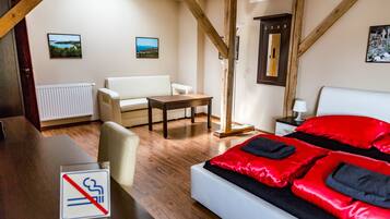 Habitación de hotel con cama, escritorio, silla, sofá y vistas al exterior.