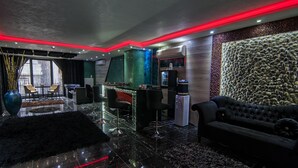 Ein modernes Interieur mit Barbereich, Sitzgelegenheiten und einer Wandverkleidung.