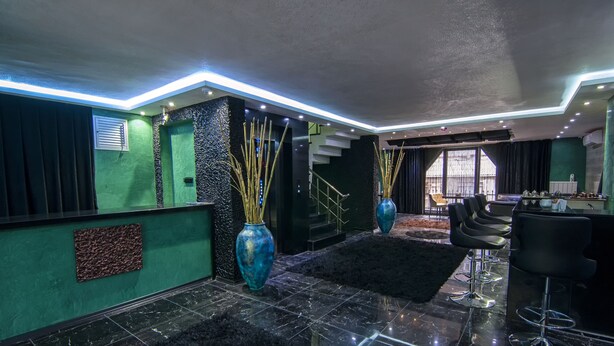 Ein modernes Interieur mit Treppe, schwarzen und grünen Wänden sowie einer Bar.