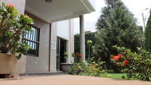 Un bâtiment avec une grande plante en pot et une enseigne sur le mur.
