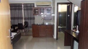 A compact hotel room with a kitchenette, a dining area, and a bathroom. - Primal Hotel Ikeja GRA (Lagos)