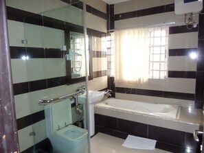 Chambre exécutive | Salle de bain | Baignoire et douche séparées, articles de toilette griffés