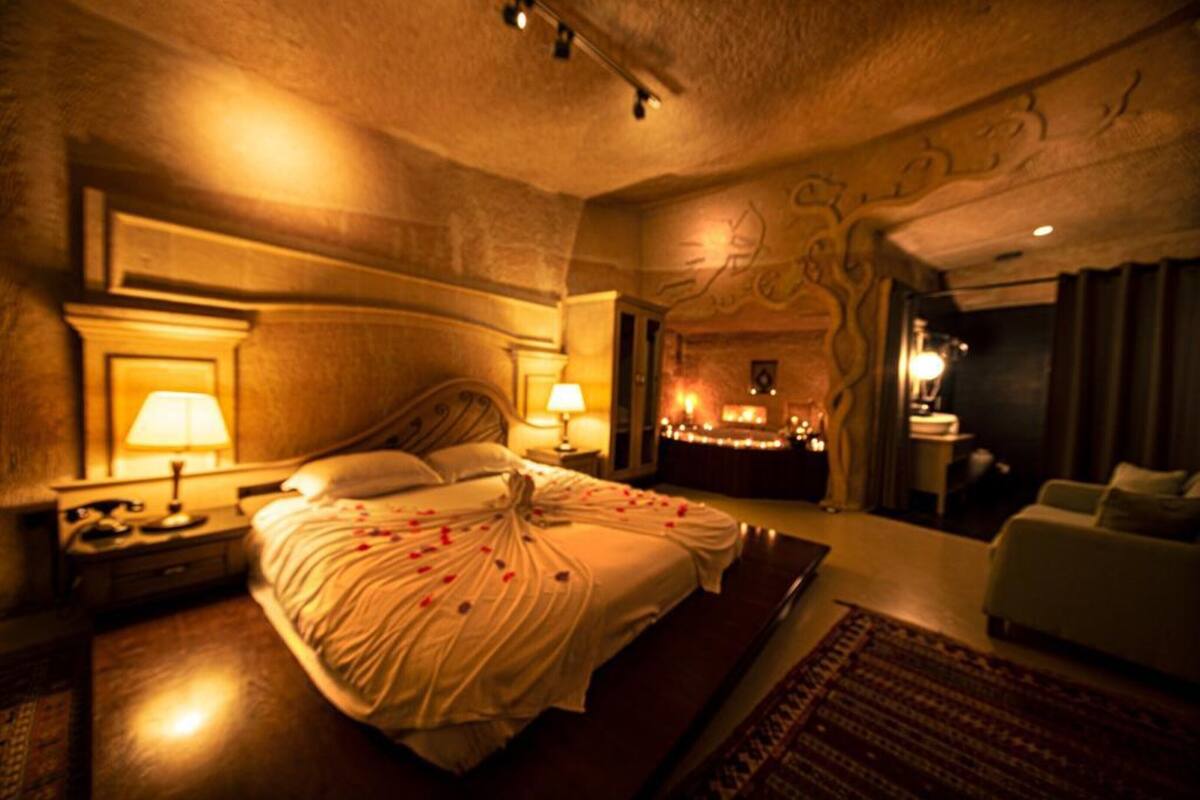 A hotel room with a large bed, bedside lamps, a nightstand, and a view of the room's interior.