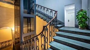 A staircase with ornate metal railings and a potted plant on the landing. - Martelli 6 Suites and Apartments (Florence)