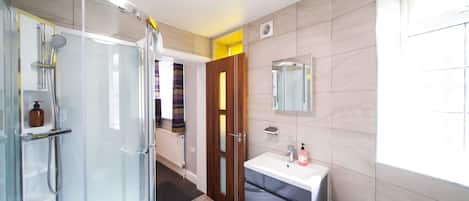 Une salle de bain moderne avec une douche à parois de verre, un meuble-lavabo avec un miroir et des toilettes.