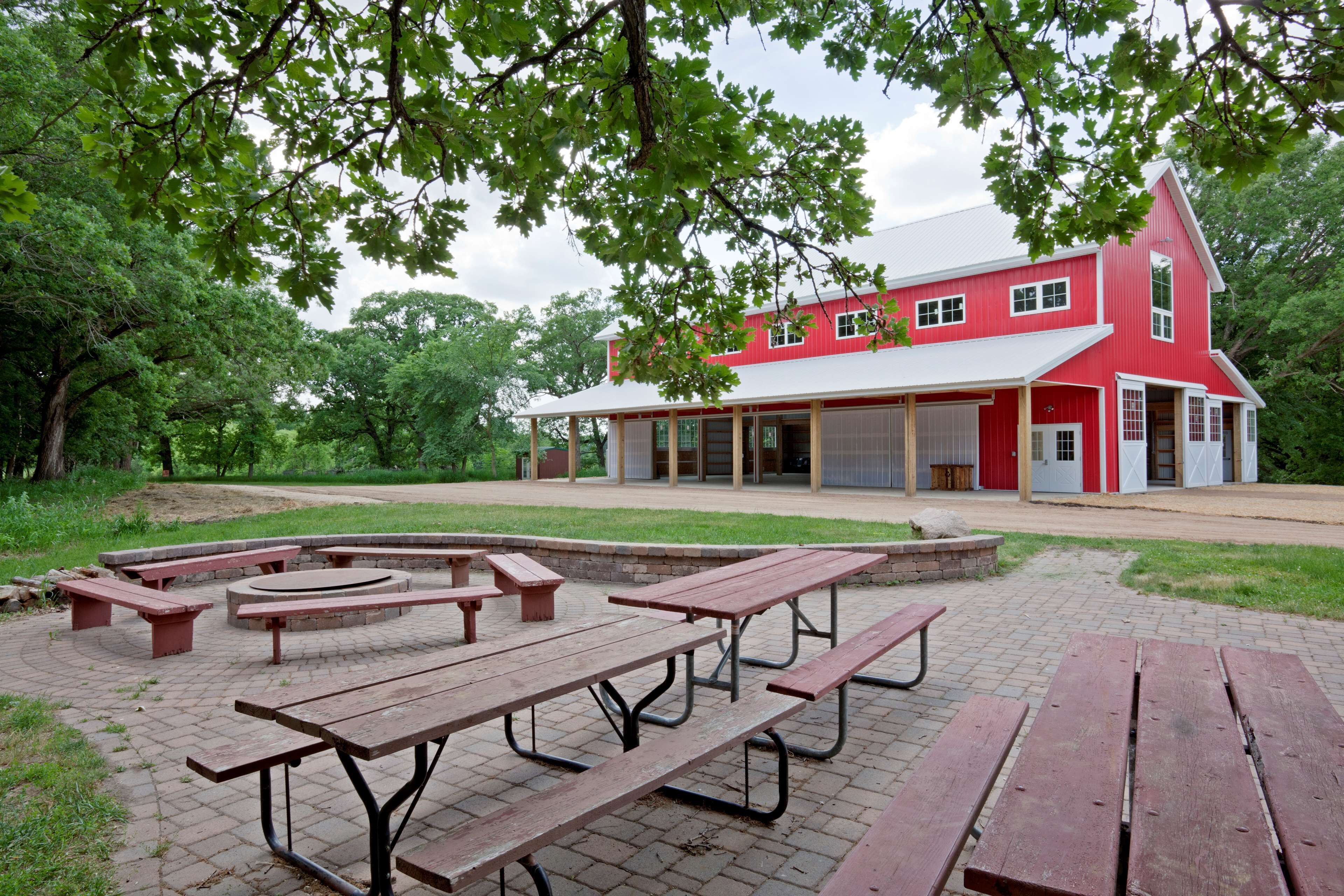 A red building with a white roof and a covered patio area with picnic tables.