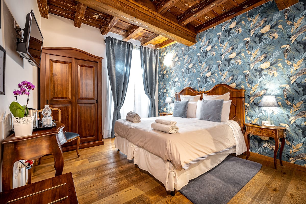 A bedroom with a wooden bed, a desk, and a chair.