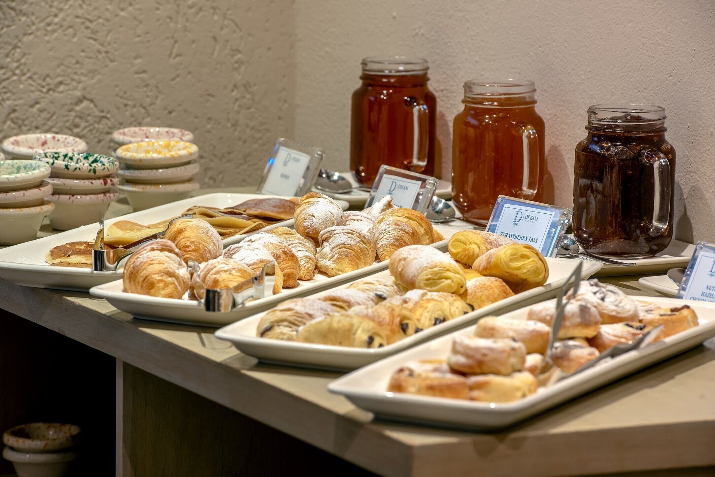 A buffet with various pastries and jams.