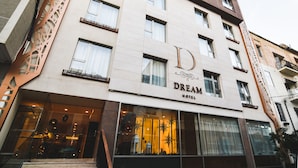 Ein mehrstöckiges Hotel mit einem markanten 'D'-Logo an der Fassade, großen Fenstern und einem modernen architektonischen Design.