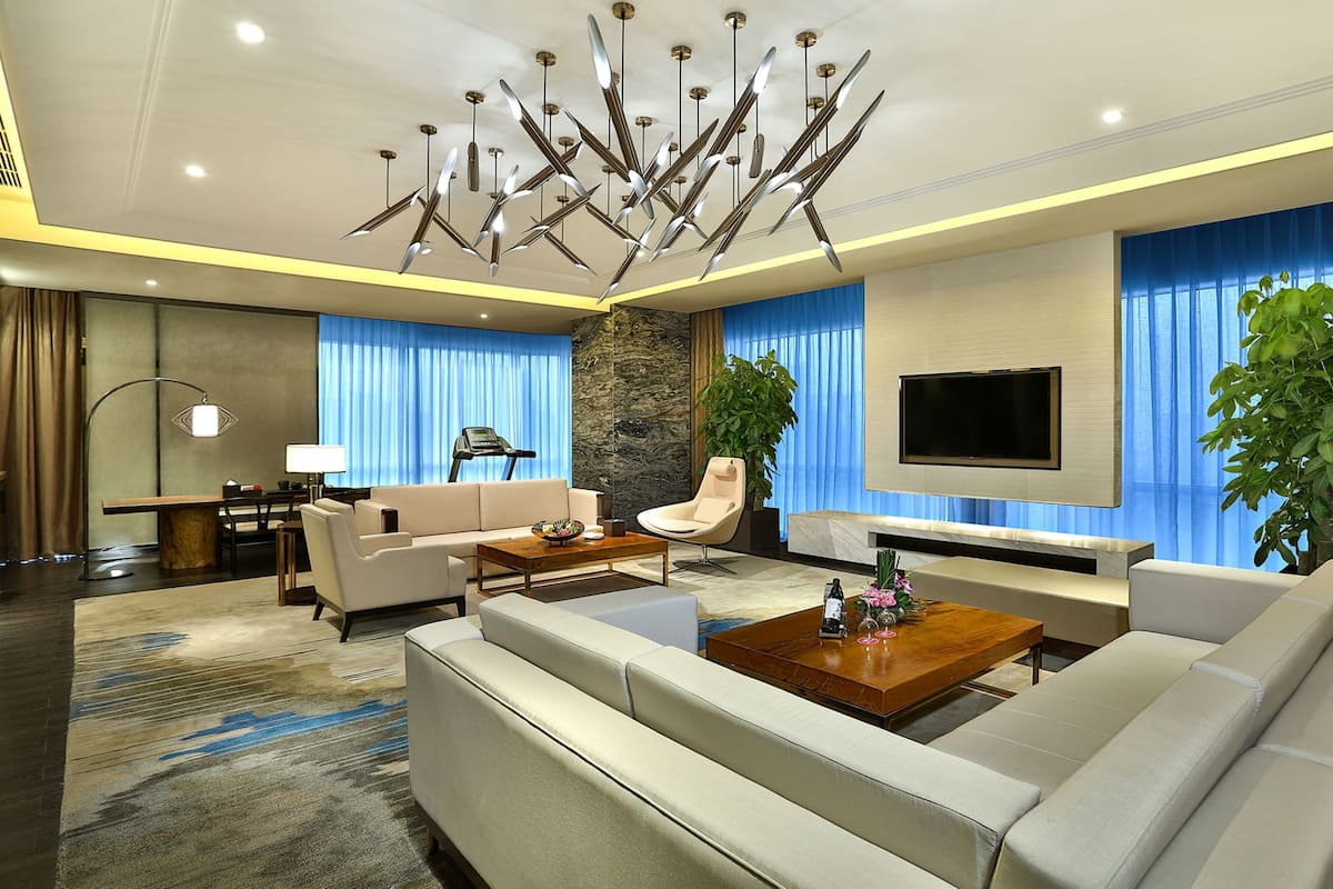 A modern living room with a sofa, coffee table, and a TV mounted on the wall.