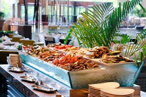 A buffet with seafood and a palm tree in the background. - Crowne Plaza Chengdu Wenjiang by IHG (Chengdu)