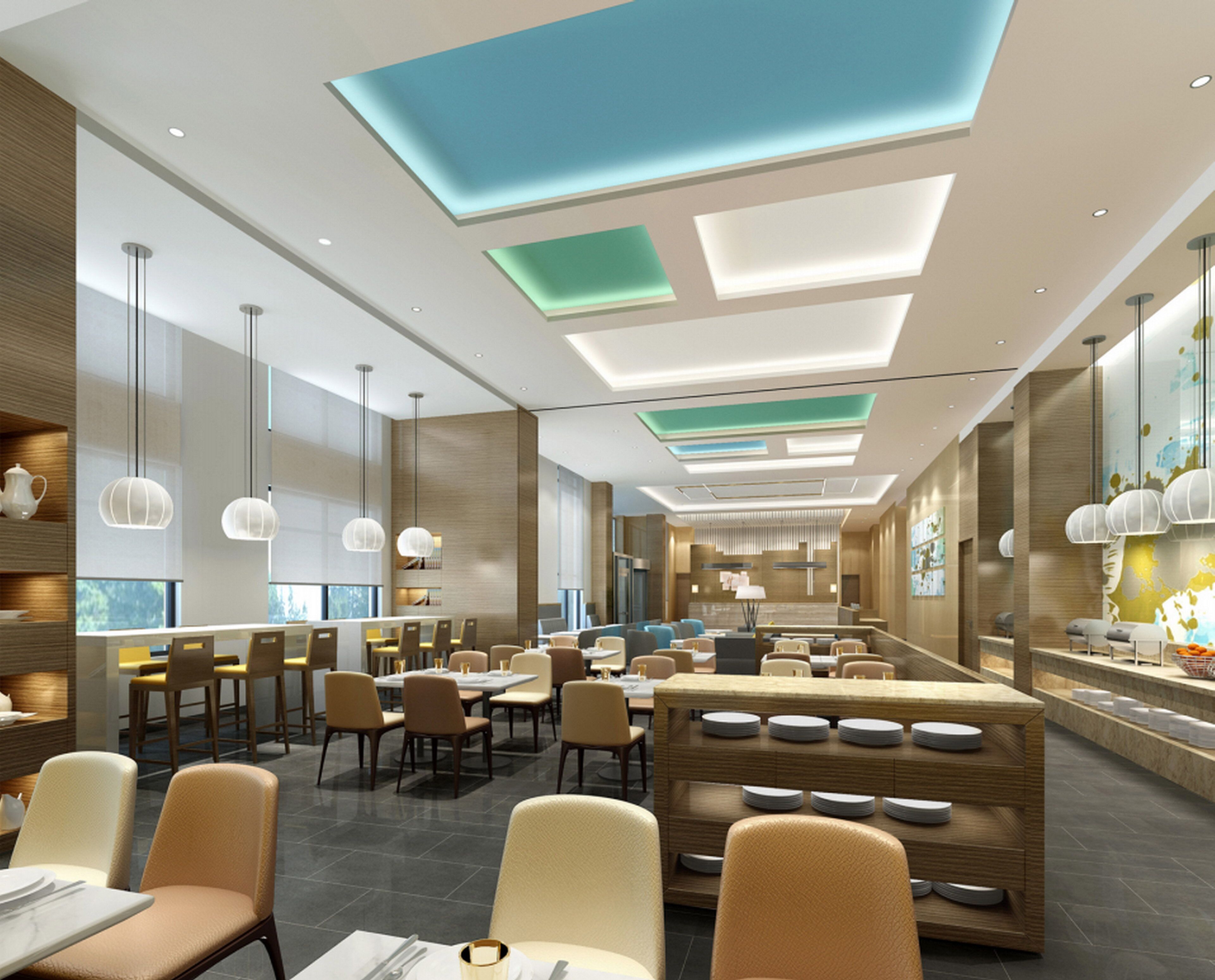 A modern restaurant interior with high ceilings, pendant lighting, and a central seating area.