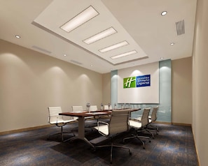 A conference room with a long table, six chairs, and a large screen displaying a logo. - Holiday Inn Express Langfang Park View by IHG (Langfang)