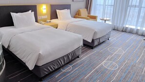 A hotel room with two beds, a bedside table with a lamp, a chair, and a large window with curtains. - Holiday Inn Express Shijiazhuang Heping by IHG (Shijiazhuang)