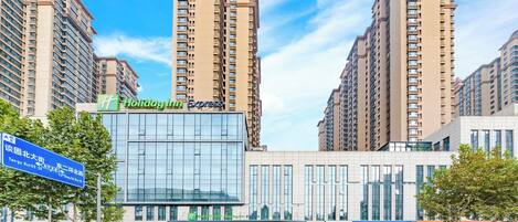 A modern hotel with a glass facade, multiple floors, and a prominent 'Holiday Inn Express' sign.