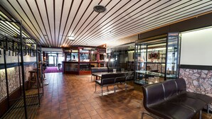 A spacious lobby with a high ceiling, a bar area, and seating arrangements.