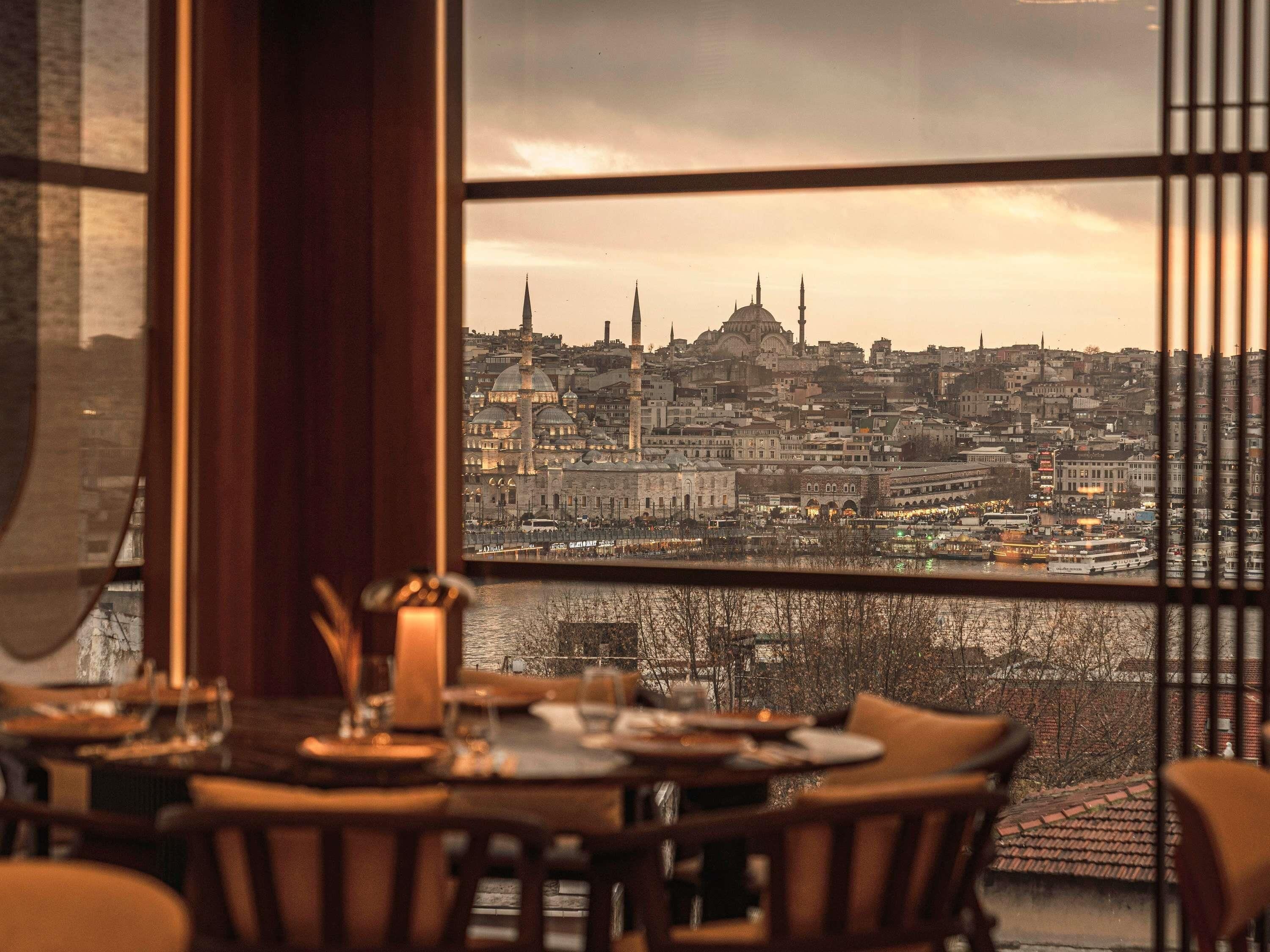 A dining area with a view of a cityscape through a window.