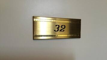 A brass room number plaque with the number 32.