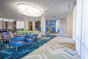 A modern lobby with a seating area, a patterned wall, and a large chandelier. - Holiday Inn Express & Suites Orlando at SeaWorld by IHG (Orlando)