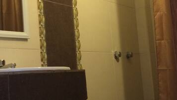 A bathroom with a toilet, sink, and shower.