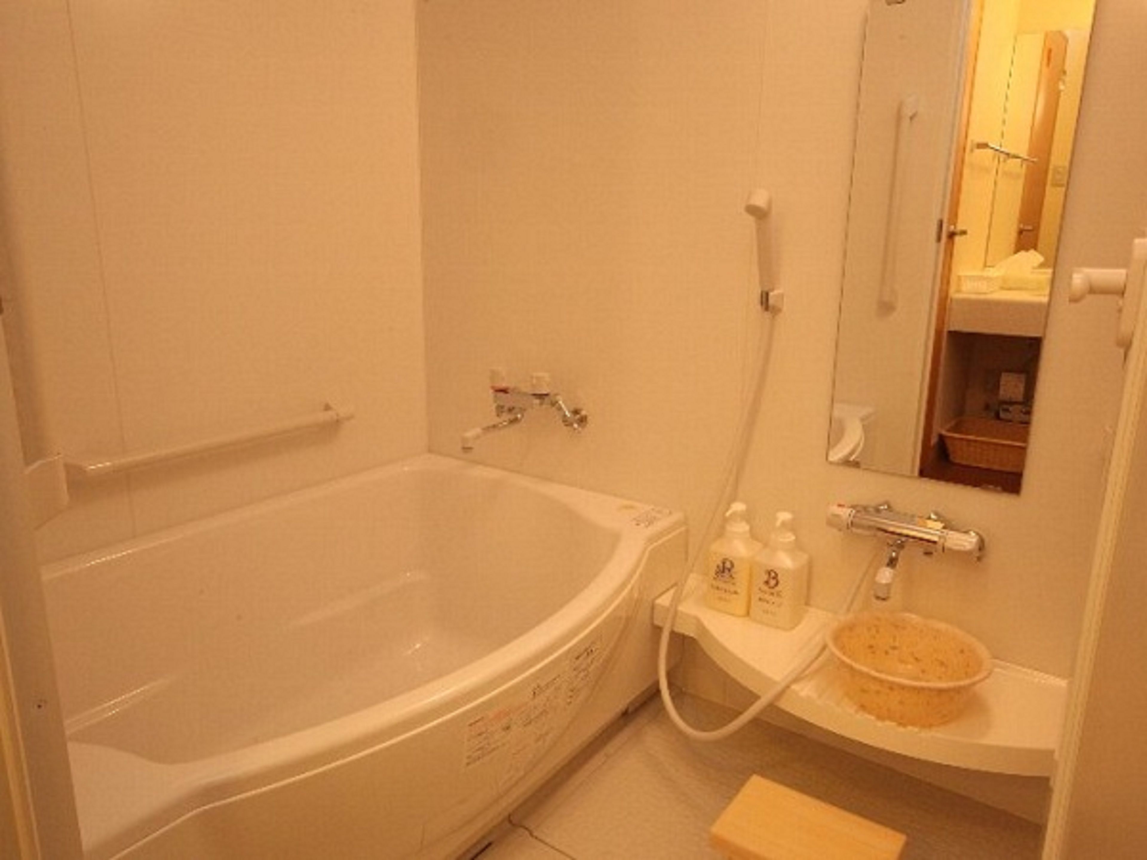 Een badkamer met een bad, een wastafel en een spiegel.