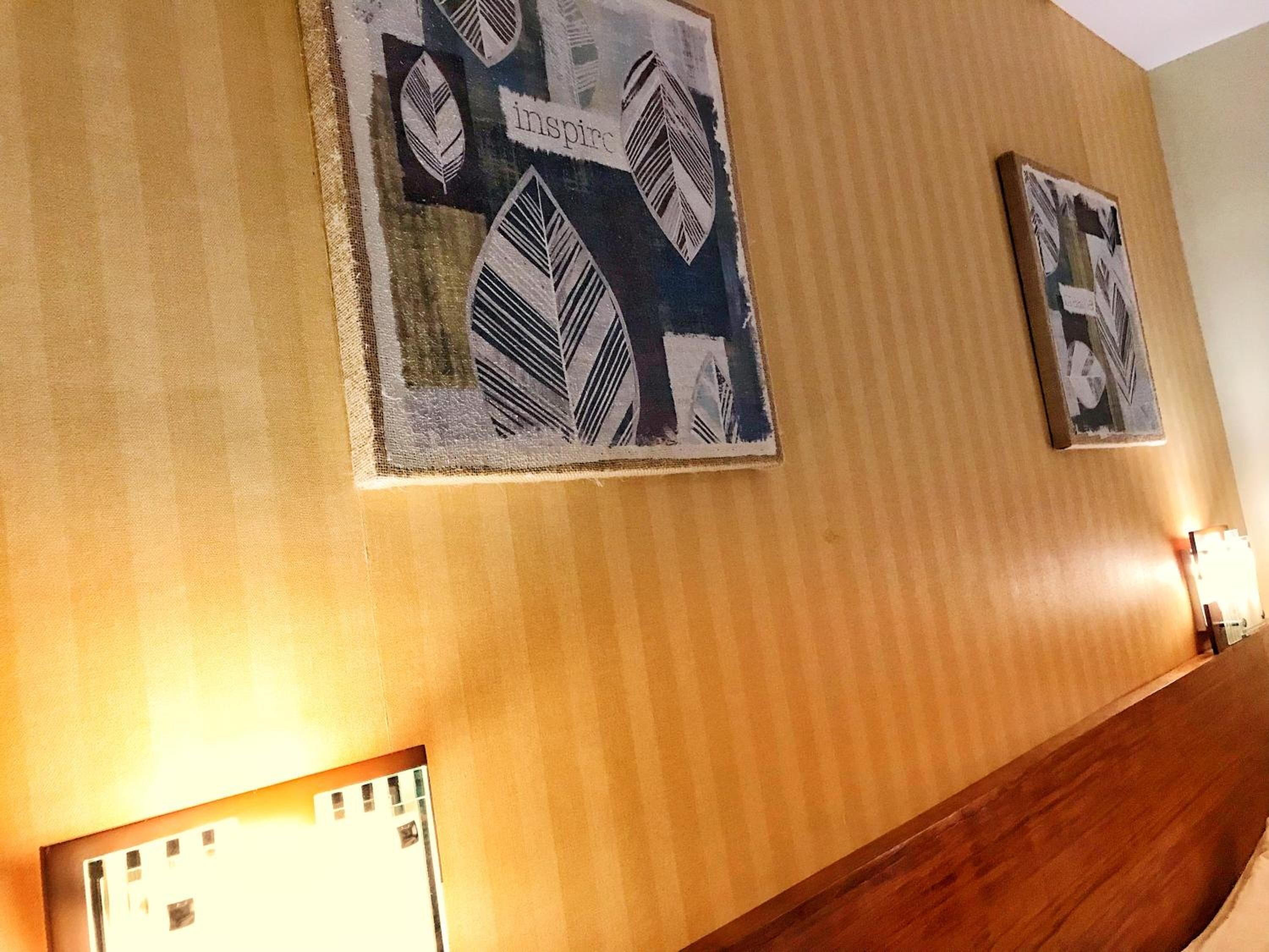 A hallway with wooden paneling and two framed artworks on the wall.
