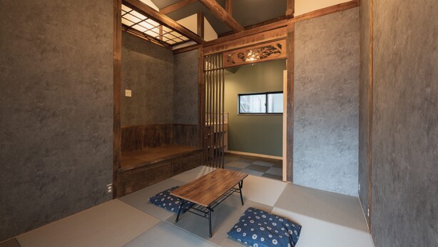 Una habitación tradicional con tatami, una mesa de madera baja, esteras de tatami y un puertas correderas.