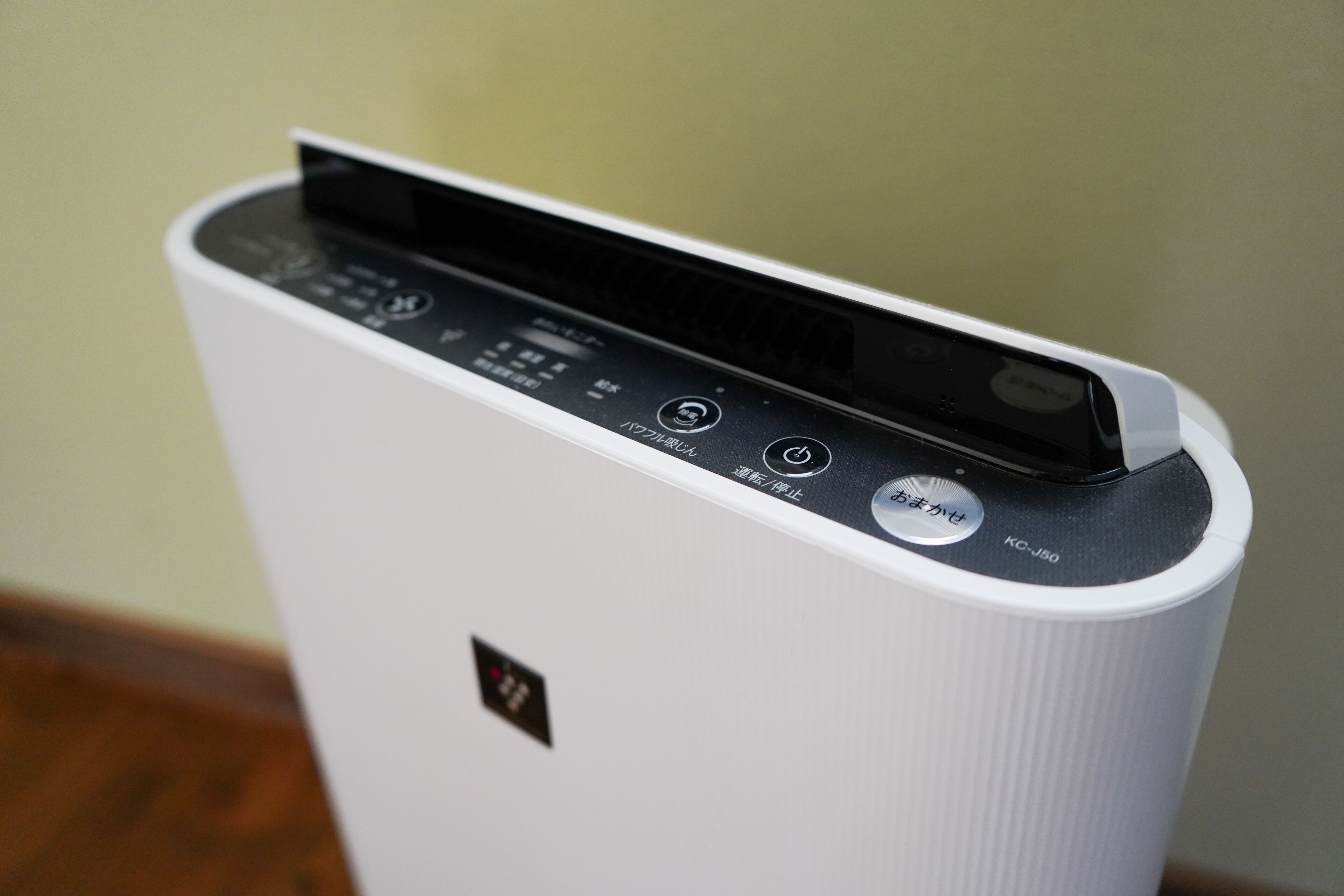 A white portable air purifier with a control panel and a black top.