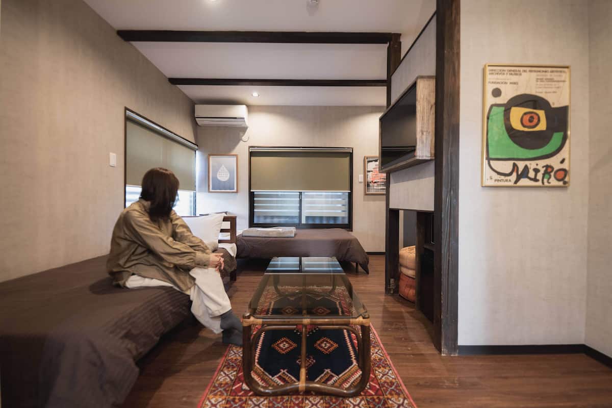 Um espaço de estar compacto com um sofá, uma mesa de centro pequena e uma cama.