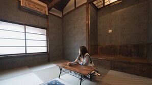 Una habitación japonesa tradicional con suelo de tatami, una mesa de madera baja y una puerta corredera.