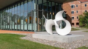 A modern building with a glass facade and a distinctive white sculpture in front. - Saxon Inn (Alfred)