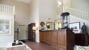 A spacious living area with a wooden coffee table, a large wooden cabinet, and a staircase leading to an upper level. - Saxon Inn (Alfred)