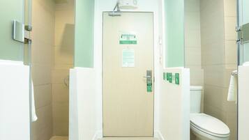 Une salle de bain équipée d’une douche, de toilettes et d’une porte dotée d’un panneau de commande.
