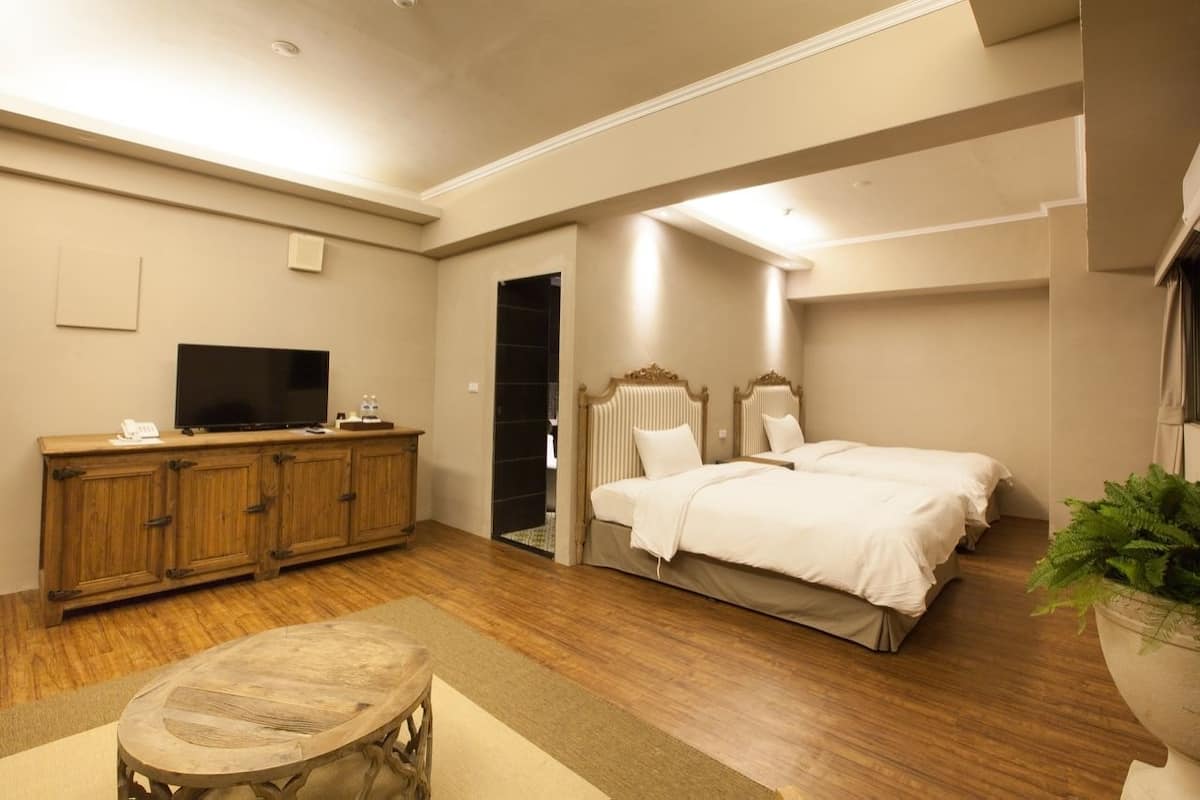 Un dormitorio con un armario de madera, un televisor, una cama y una planta en maceta.