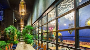 A restaurant with a long wooden table, blue chairs, and hanging lanterns. - Hotel Royal Kingdom (Beinan)