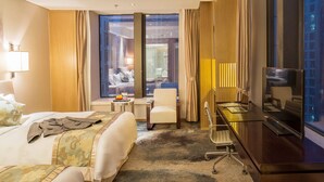 Ein Hotelzimmer mit Bett, Schreibtisch, Stuhl und Fernseher.