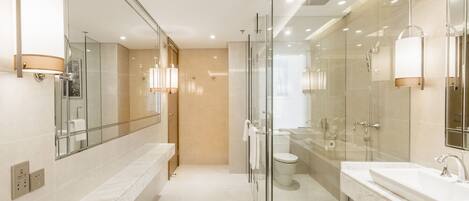 A modern bathroom with a glass shower enclosure, a separate toilet, and a vanity with a sink.