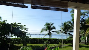 A table set for two with a view of the sea and palm trees. - Sand Dollar Beach Bed & Breakfast (Bocas del Toro)
