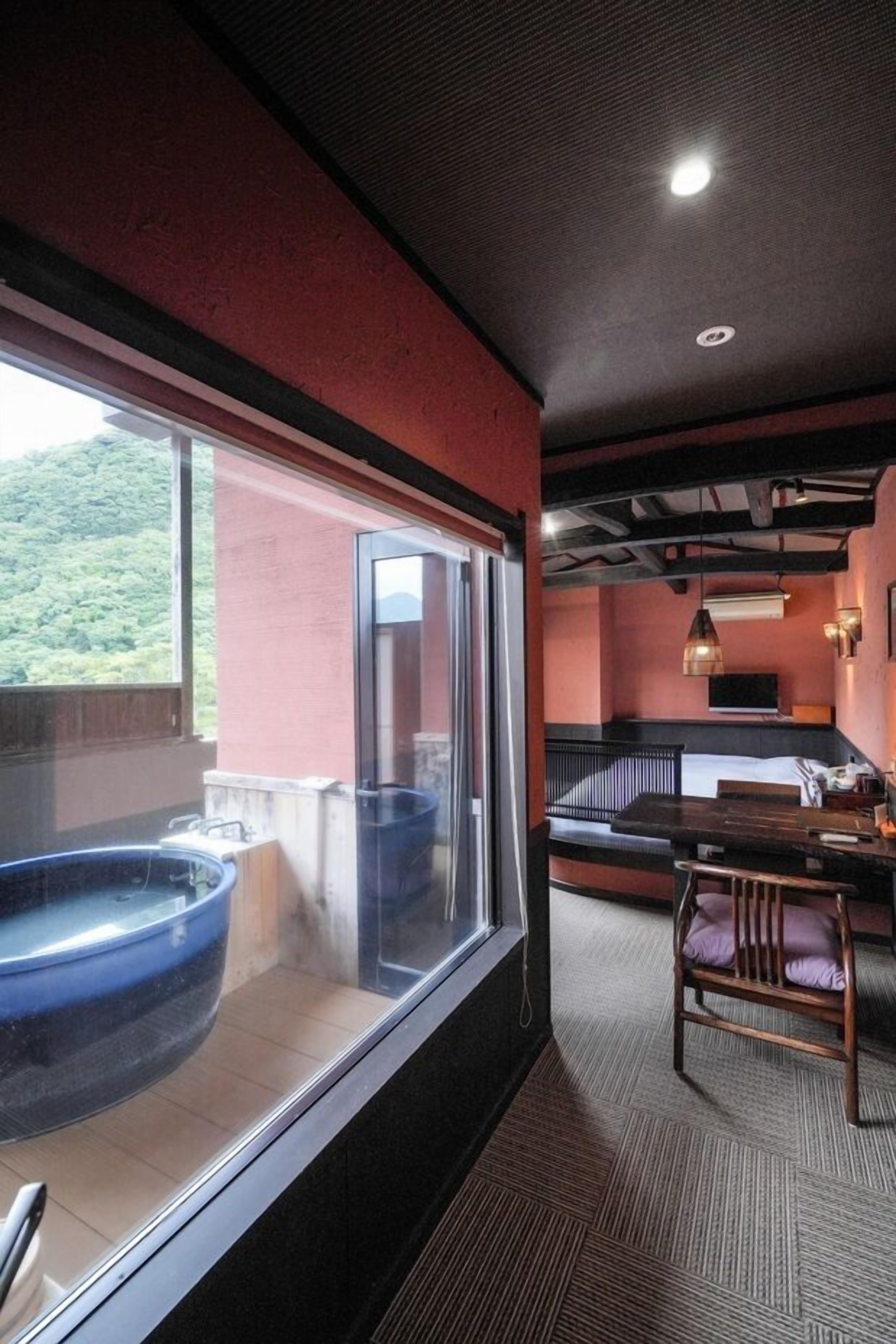 Ein Zimmer mit großem Fenster, Whirlpool, Bett und Essbereich.