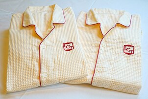 Dos camisas dobladas con un estampado texturizado y un pequeño logotipo bordado en el pecho.