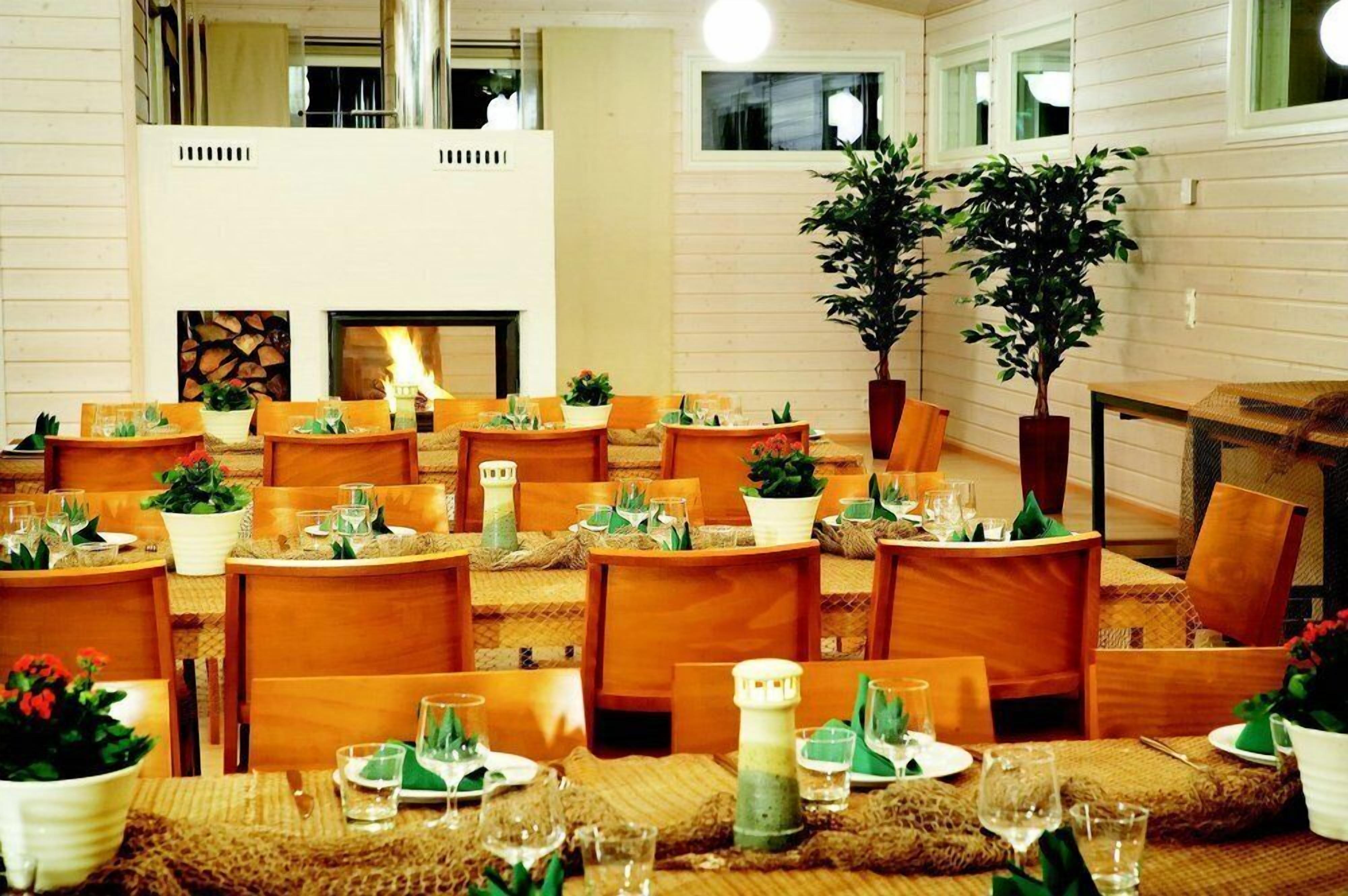 A dining area with multiple tables set for guests, featuring wooden chairs and tables with woven placemats.