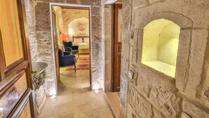 A stone-walled corridor with a wooden door and a small alcove. - Bedrock Cave Hotel - Adults Only (Nevsehir)