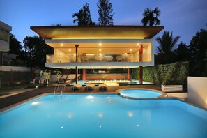 Una piscina al aire libre, sillones reclinables de piscina