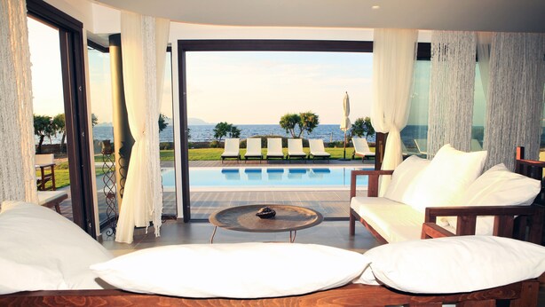 A modern room with a view of the sea, a pool, and outdoor seating. - Kouvohori Villas Crete (Hersonissos)