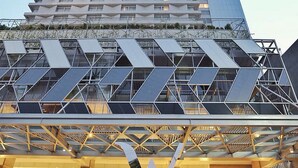Un hotel moderno con una fachada geométrica distintiva y un letrero llamativo.