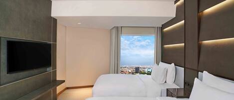 Una habitación de hotel moderna con un televisor grande, dos camas, vistas a la ciudad y un diseño minimalista.