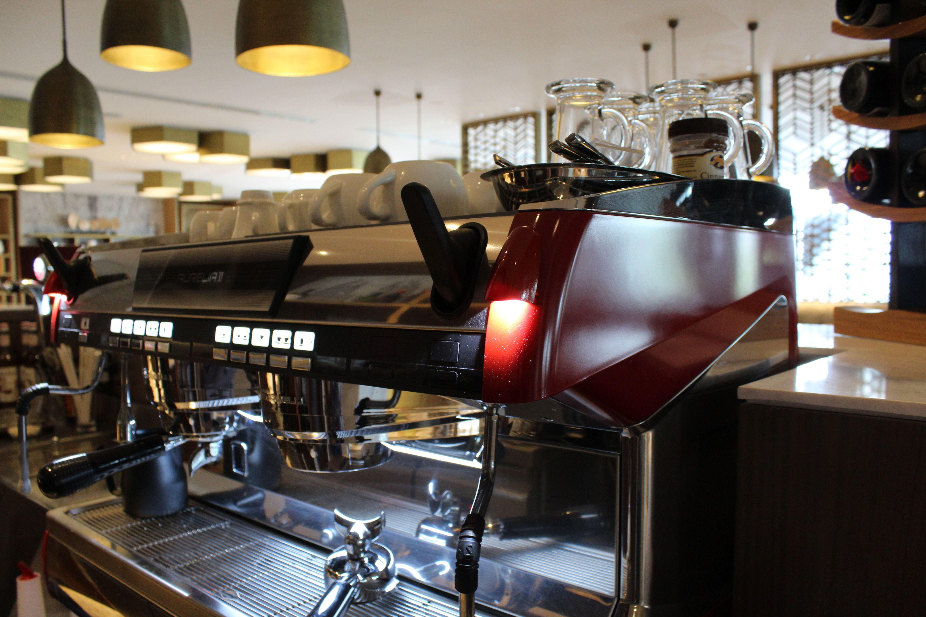 A coffee machine with a digital display and a steam wand.