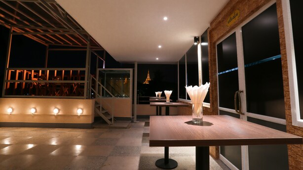 An indoor dining area with a wooden table, chairs, and a staircase leading to an upper level. - Hotel H Valley Yangon (Yangon)