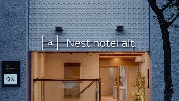 The exterior of Nest Hotel Alt. with a textured facade, a visible entrance, and a sign indicating a bar and chill area. - Nest Hotel Olt Kawasaki Station (Kawasaki)
