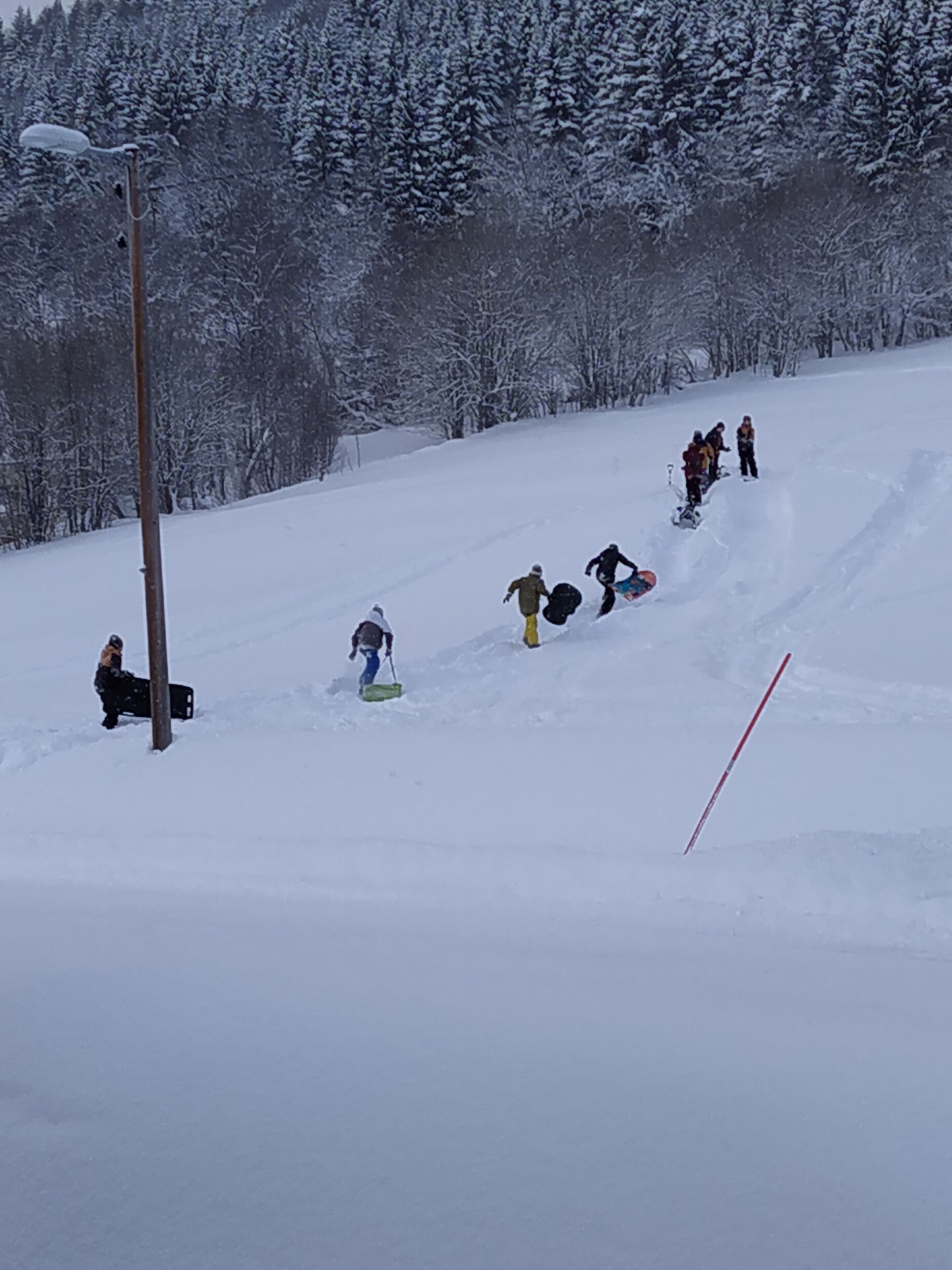 A snowy slope with people skiing and snowboarding.